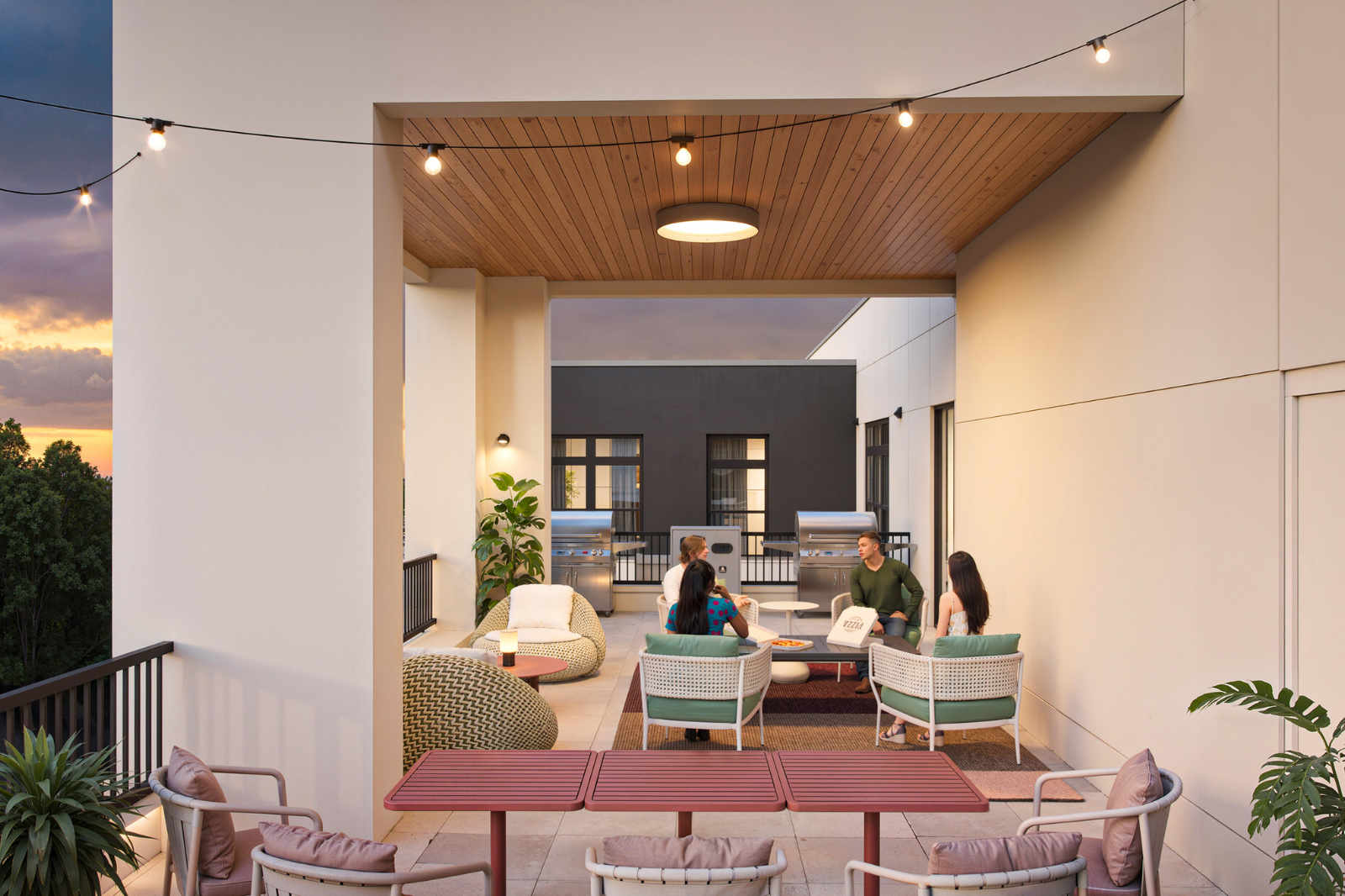 Exterior RoofTerrace Covered rooftop terrace with lounge seating, grilling stations, string lights, and outdoor gathering space designed for resident socializing.
